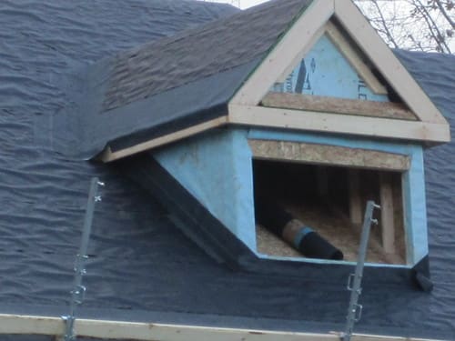 Dormer roof detail with exposed sheathing and roofing felt