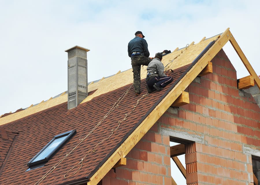 Roofing crew working along a ridge line